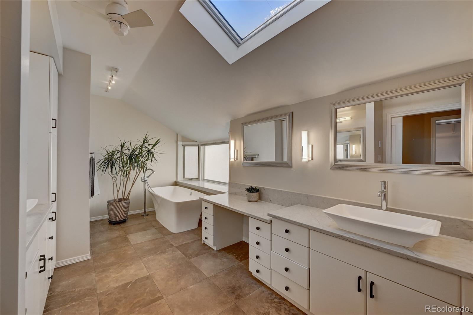 358 Steele Street Denver, CO 80206 - Photo 16 of 30 a spacious bathroom with double sink a toilet a window and a shower