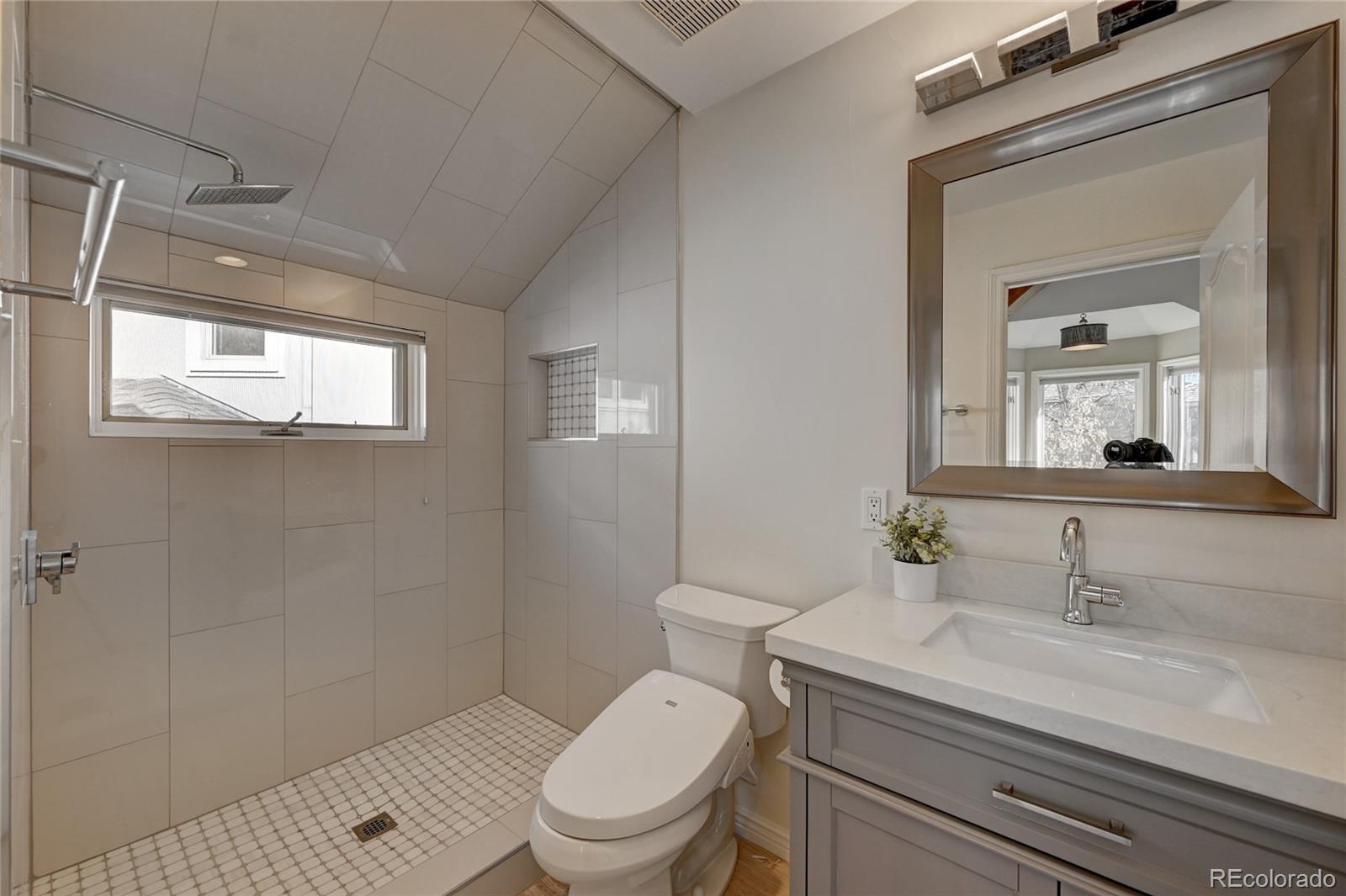 358 Steele Street Denver, CO 80206 - Photo 22 of 30 a bathroom with a toilet a sink and mirror