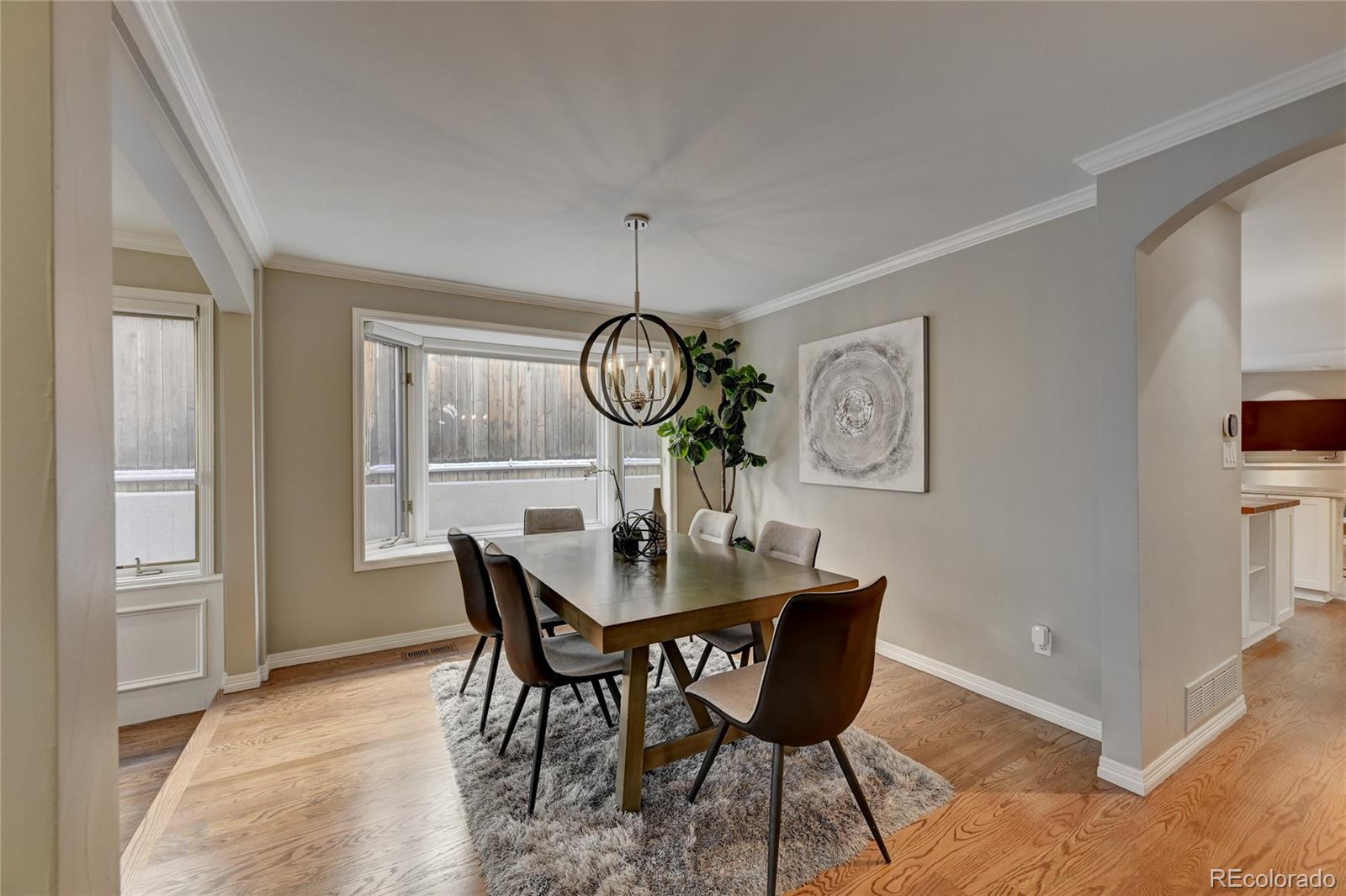 358 Steele Street Denver, CO 80206 - Photo 6 of 30 a view of a dining room with furniture wooden floor and a chandelier