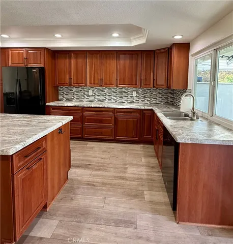 a view of a patio with lawn chairs under an umbrella with large trees