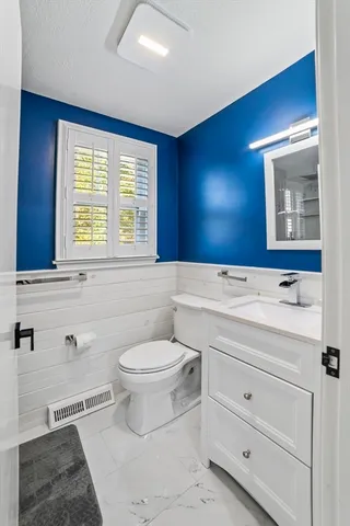 a bathroom with a toilet sink and mirror