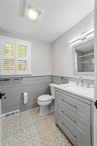 a bathroom with a toilet sink and mirror