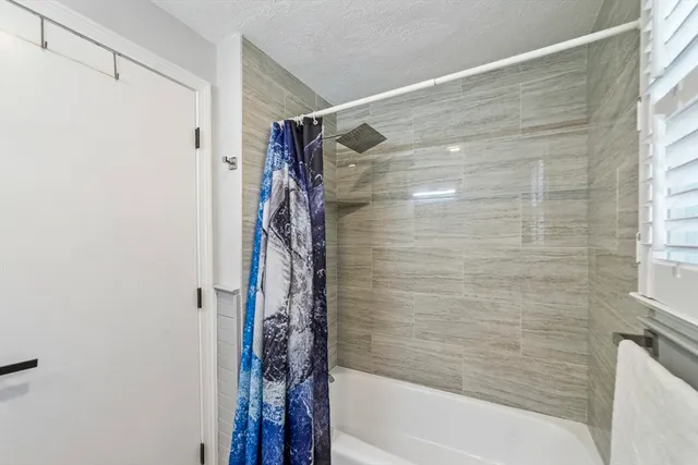 a bathroom with a shower curtain and a bathtub