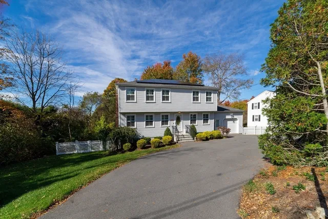 a front view of a house with a yard and trees