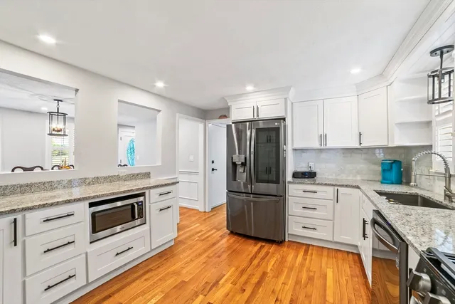 a kitchen with granite countertop a refrigerator stove and sink