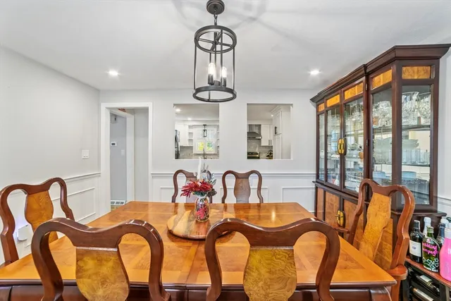 a view of a dining room with furniture a chandelier and large window