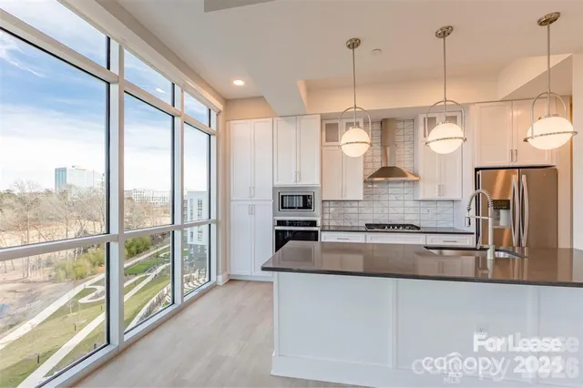 a kitchen with stainless steel appliances granite countertop a sink a stove and a refrigerator