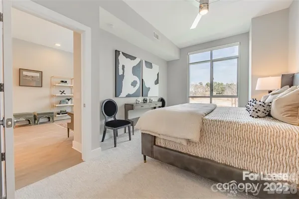 a spacious bedroom with a bed and a chandelier