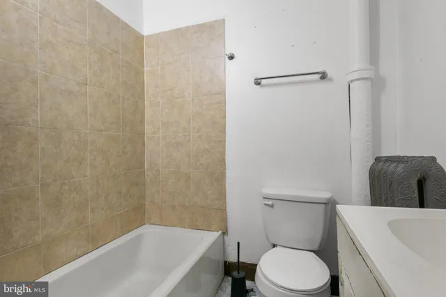 a white toilet sitting next to a bath tub
