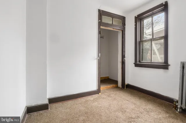 an empty room with windows and closet