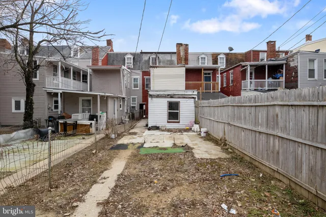 a view of a yard with wooden fence