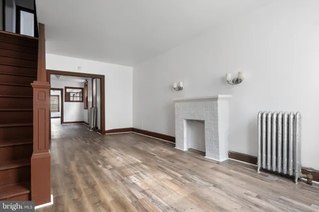 an empty room with windows and fireplace