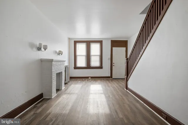 a view of a hallway with wooden floor and staircase