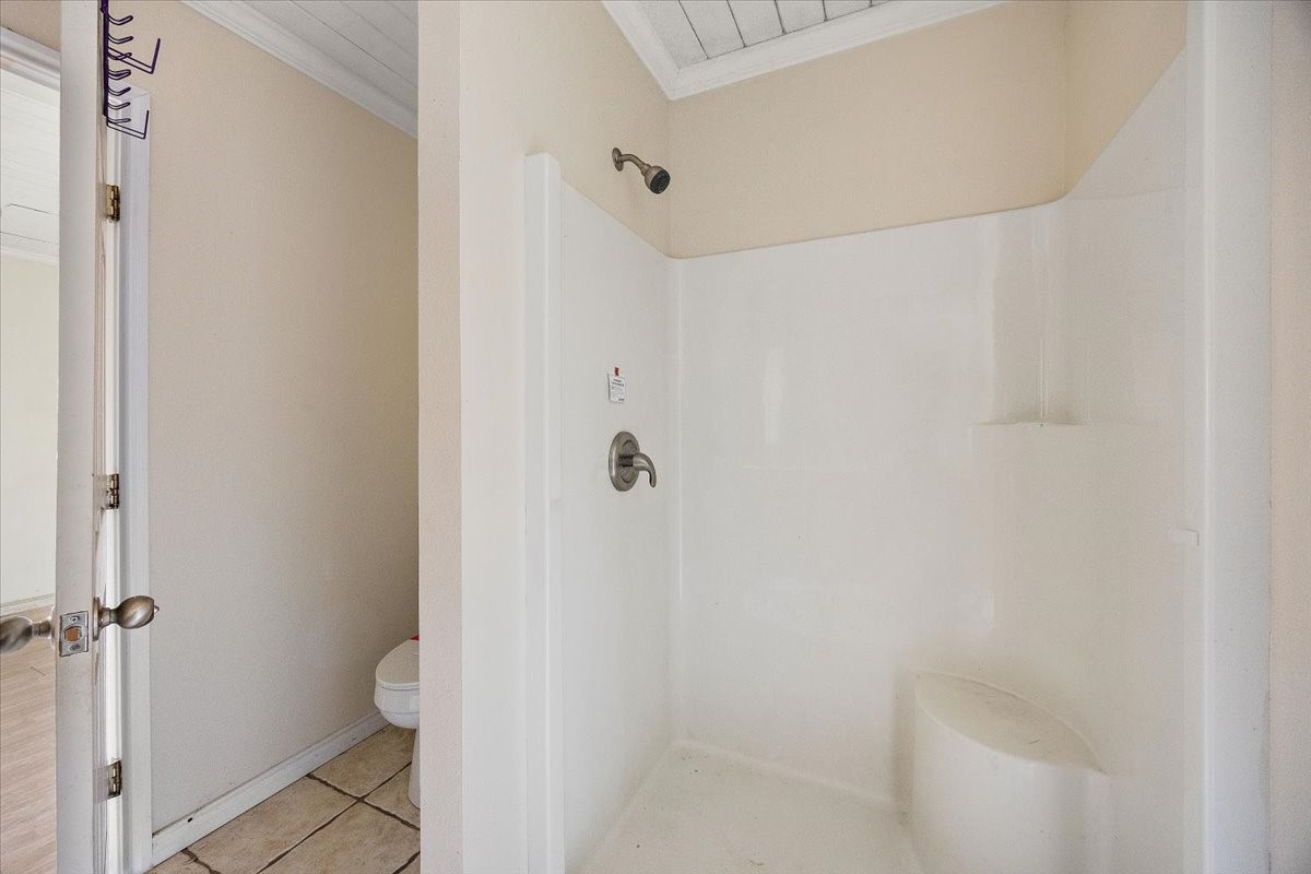 370 Austin Street Timpson, TX 75975 - Photo 23 of 30 a bathroom with a granite countertop white toilet and a shower