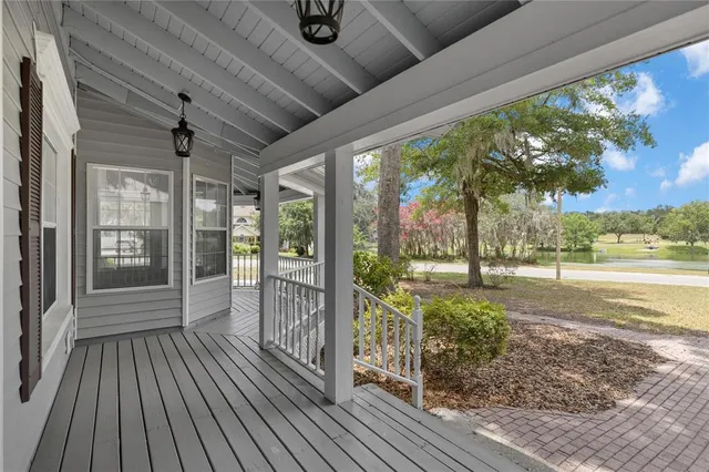 a view of an empty room with wooden floor and windows