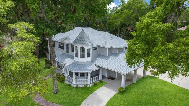 a aerial view of a house with a yard and large trees
