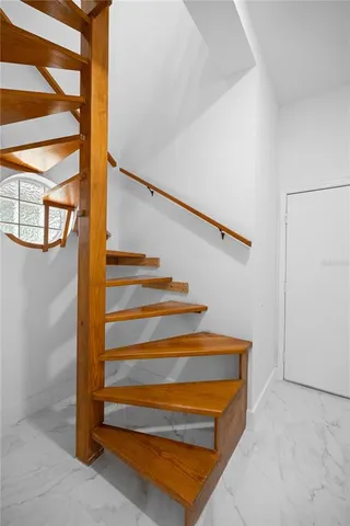an empty room with wooden floor ceiling fan and windows