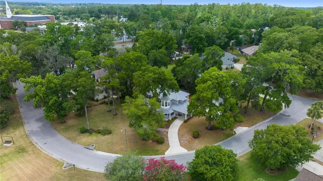an aerial view of a house with a yard and large trees