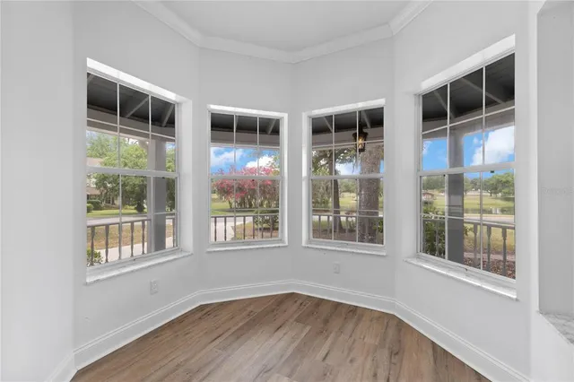 an empty room with a window and wooden floor