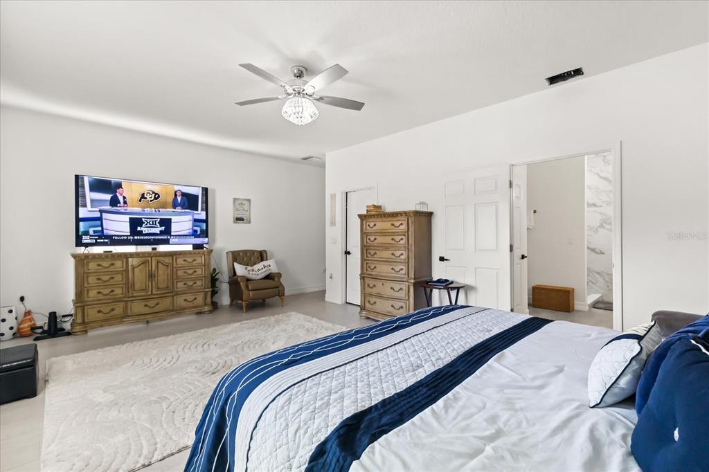 812 Chastain Road Seffner, FL 33584 - Photo 12 of 26 a bedroom with a large bed and a chandelier