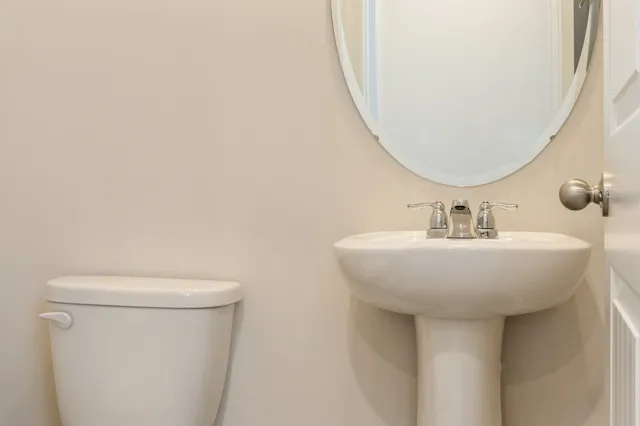 a bathroom with a sink a toilet and a mirror