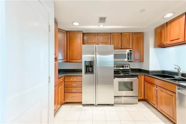 a kitchen with stainless steel appliances granite countertop a refrigerator sink and stove