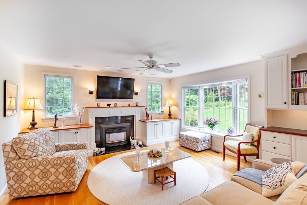 106 Hidden Valley Road Groton, MA 01450 - Photo 12 of 40 a living room with furniture a fireplace and a flat screen tv