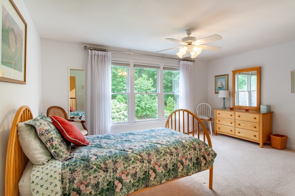 106 Hidden Valley Road Groton, MA 01450 - Photo 22 of 40 a bedroom with a bed and a chandelier