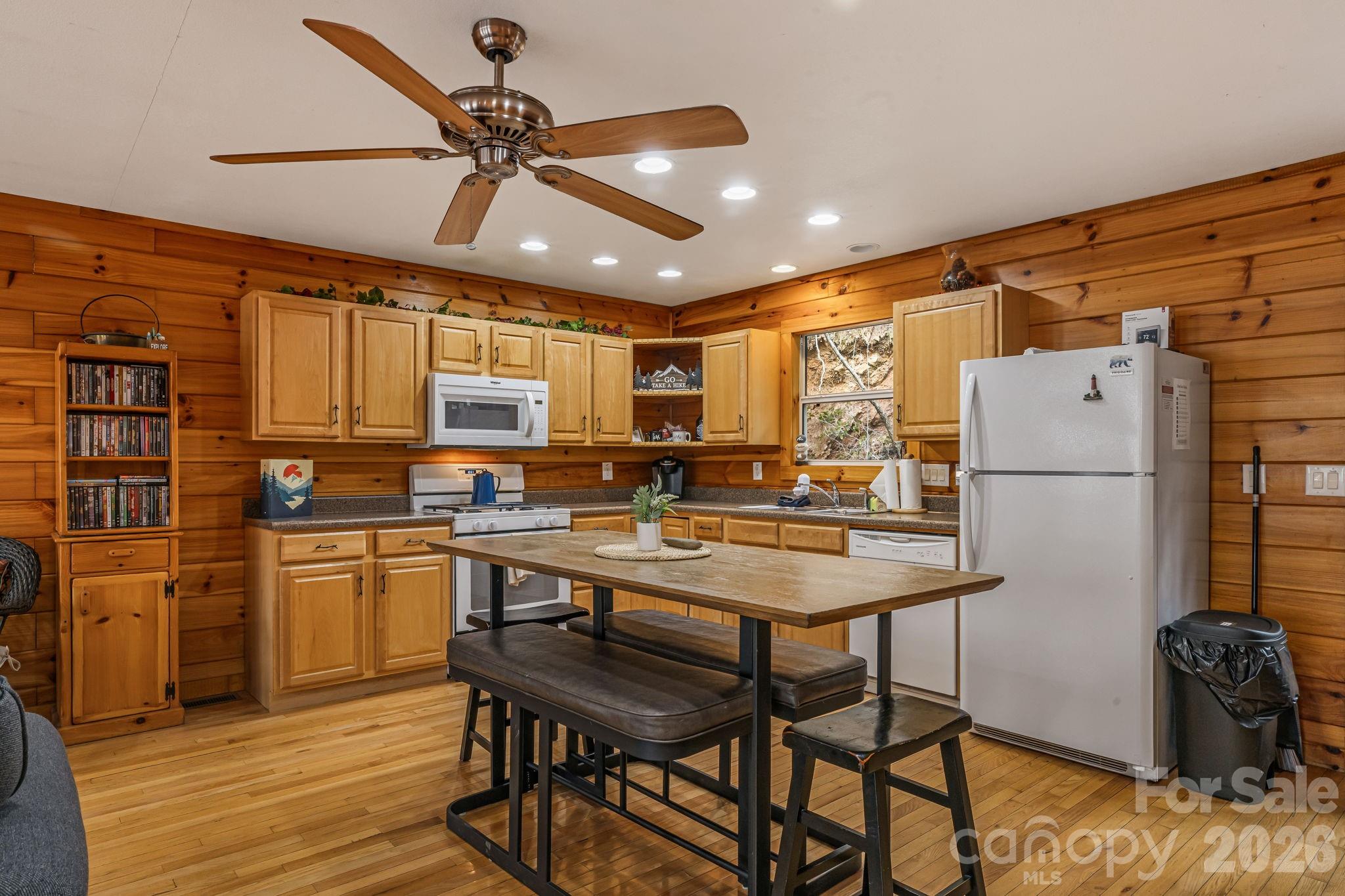 157 Crosspatch Lane Bryson City, NC 28713 - Photo 13 of 38 a kitchen with stainless steel appliances granite countertop a dining table chairs refrigerator and cabinets