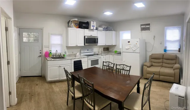 a kitchen with a table chairs microwave and cabinets