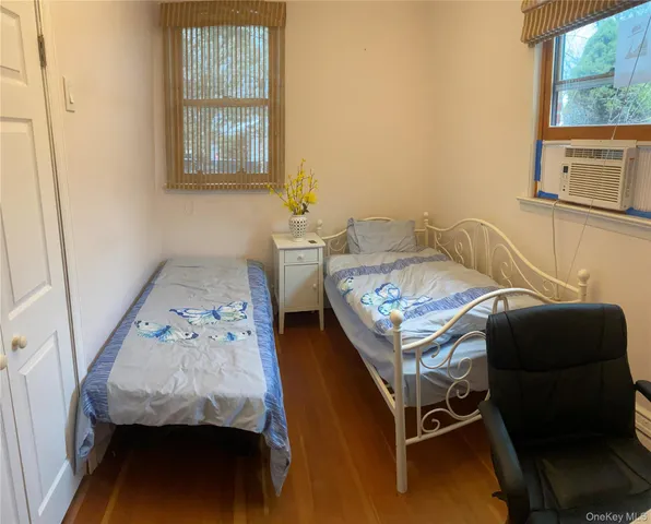 a bedroom with a bed and a dresser next to a window