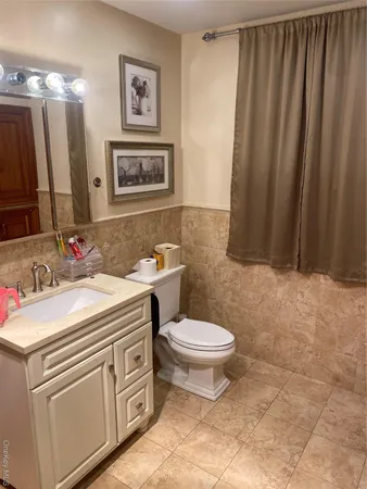 a bathroom with a toilet sink and mirror