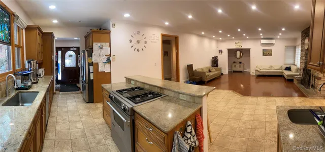 a kitchen with stainless steel appliances granite countertop a stove top oven a sink and a refrigerator