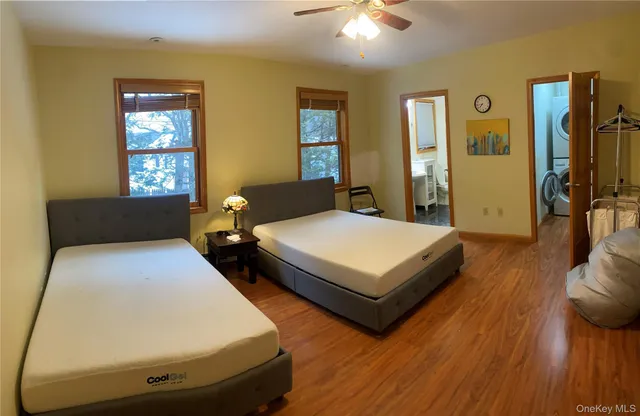 a bedroom with two beds and wooden floor