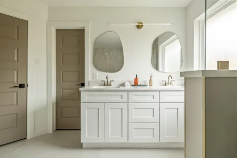 a bathroom with a double vanity sink and a mirror