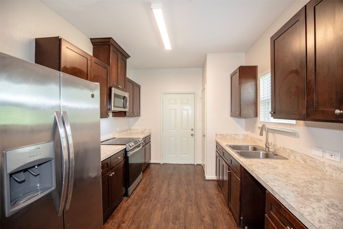 2016 H Avenue Dickinson, TX 77539 - Photo 14 of 30 a kitchen with stainless steel appliances granite countertop a refrigerator a sink and wooden cabinets