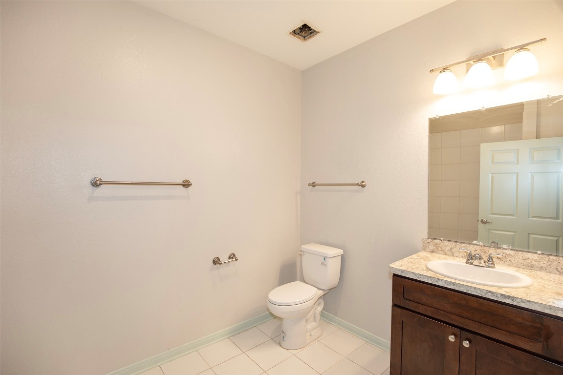 2016 H Avenue Dickinson, TX 77539 - Photo 21 of 30 a bathroom with a granite countertop toilet a sink and a mirror