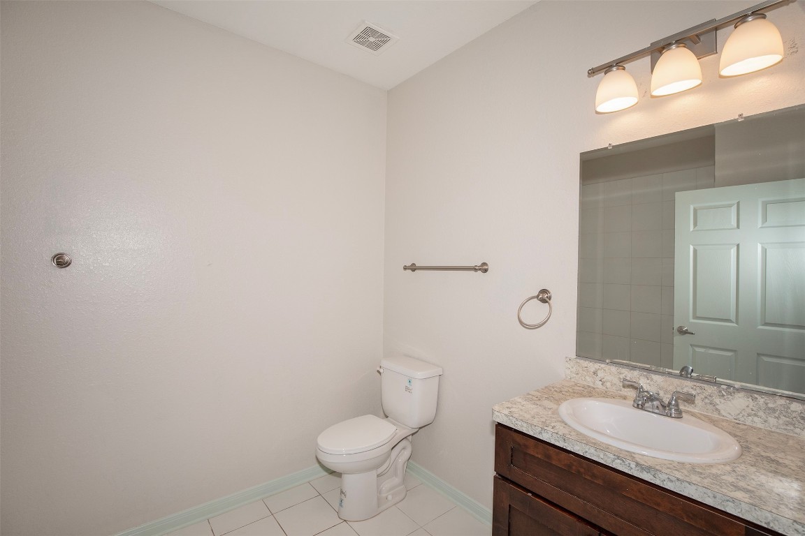 2016 H Avenue Dickinson, TX 77539 - Photo 25 of 30 a bathroom with a granite countertop sink toilet and a mirror