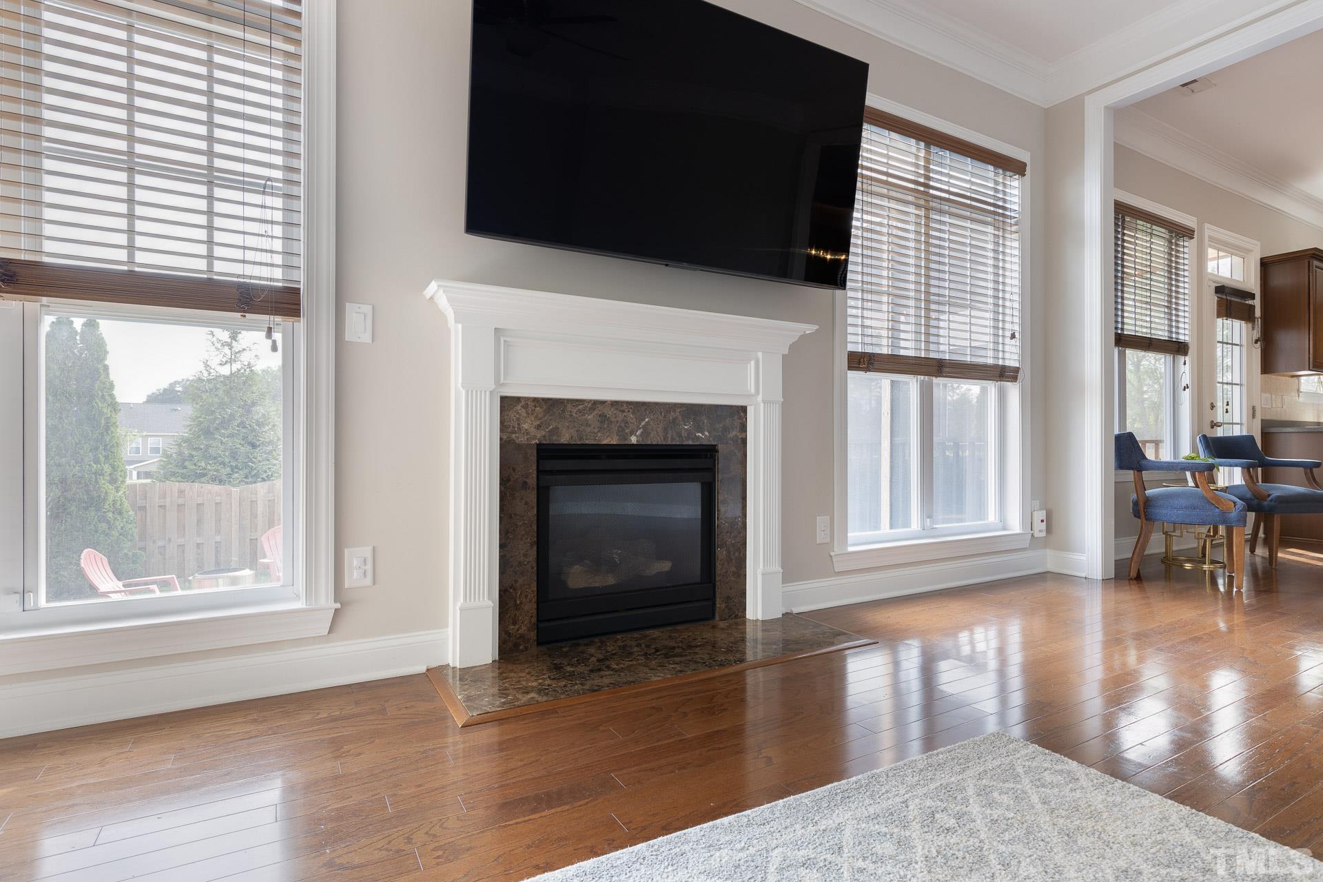 1148 Chapanoke Road Raleigh, NC 27603 - Photo 17 of 47 a living room with a fireplace a flat screen tv and a large window