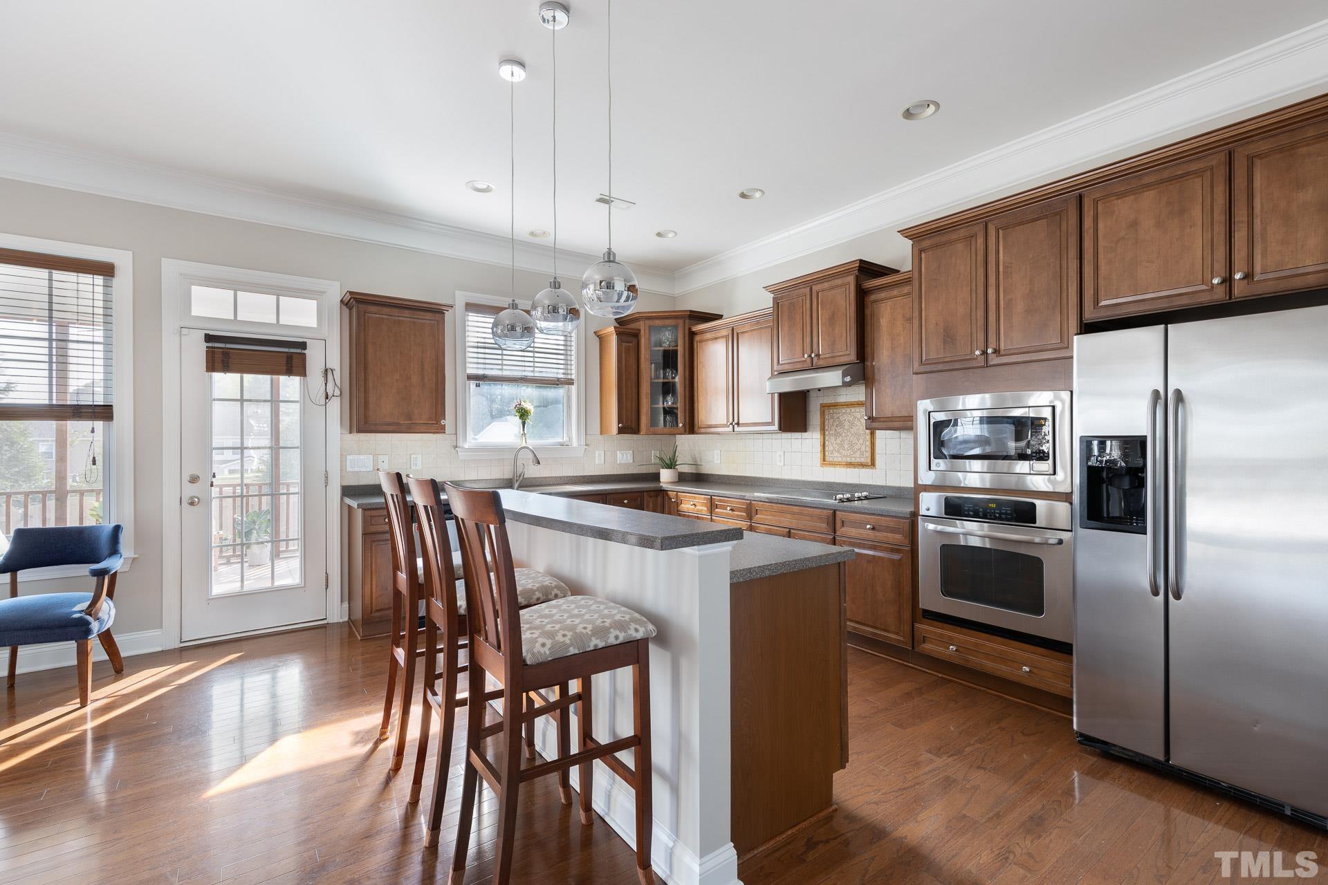 1148 Chapanoke Road Raleigh, NC 27603 - Photo 9 of 47 a kitchen with granite countertop stainless steel appliances a dining table chairs refrigerator and cabinets