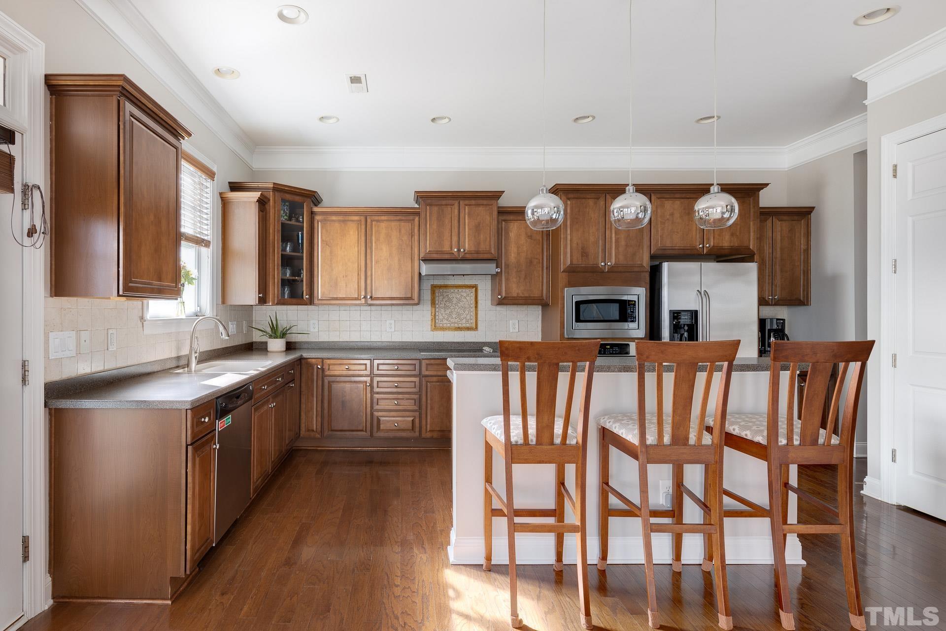 1148 Chapanoke Road Raleigh, NC 27603 - Photo 10 of 47 a kitchen with stainless steel appliances granite countertop a stove top oven a sink a dining table and chairs