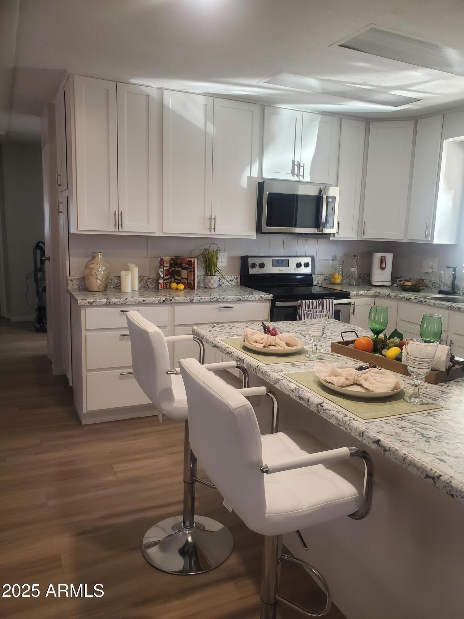 3300 East Broadway Road, Unit 128 Mesa, AZ 85204 - Photo 1 of 32 a kitchen with a sink a microwave and cabinets