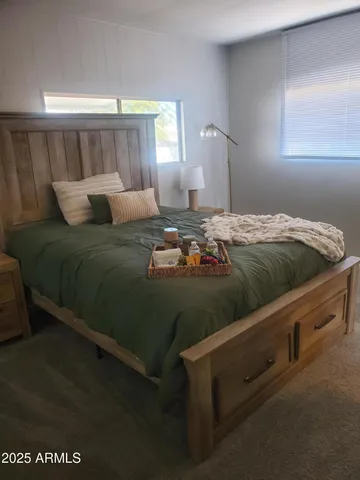 a bed sitting in a bedroom next to a window