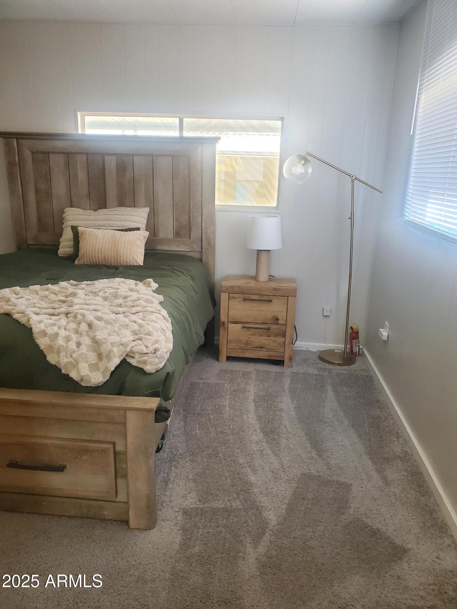 3300 East Broadway Road, Unit 128 Mesa, AZ 85204 - Photo 18 of 32 a bedroom with a bed and wooden floor