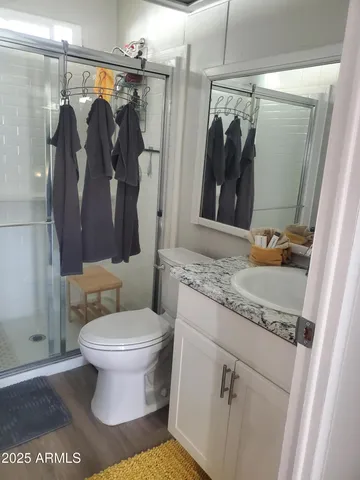 a bathroom with a granite countertop sink toilet and shower