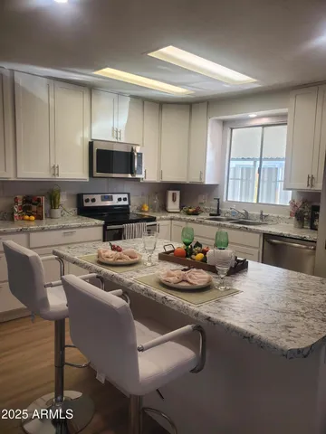 a kitchen with sink a stove a microwave and cabinets