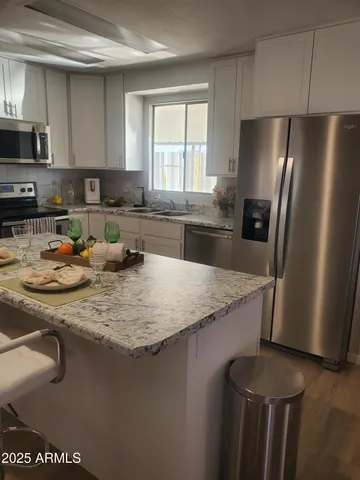 a kitchen with stainless steel appliances granite countertop a sink a stove and a refrigerator