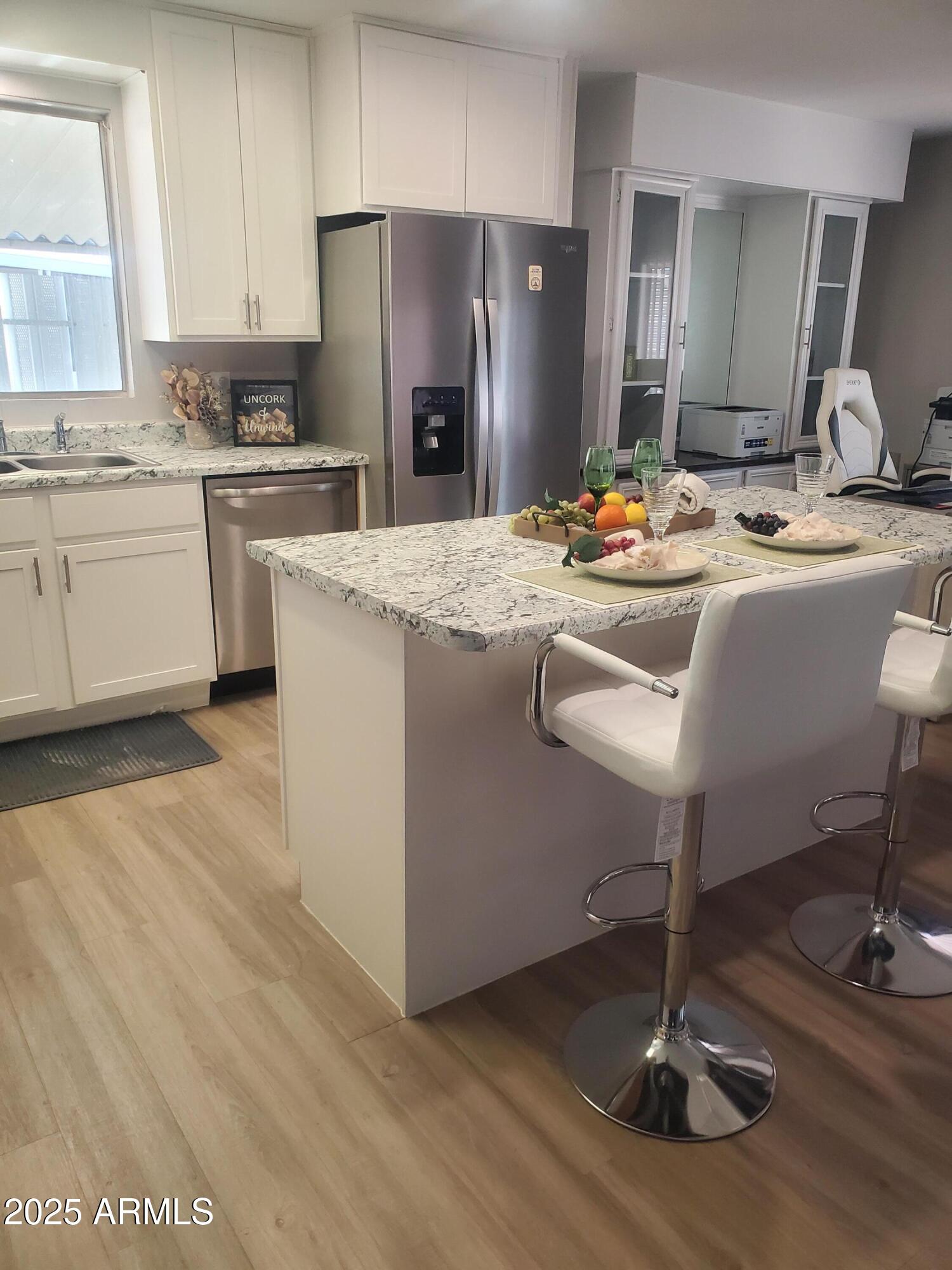3300 East Broadway Road, Unit 128 Mesa, AZ 85204 - Photo 7 of 32 a kitchen with kitchen island granite countertop a sink cabinets and stainless steel appliances