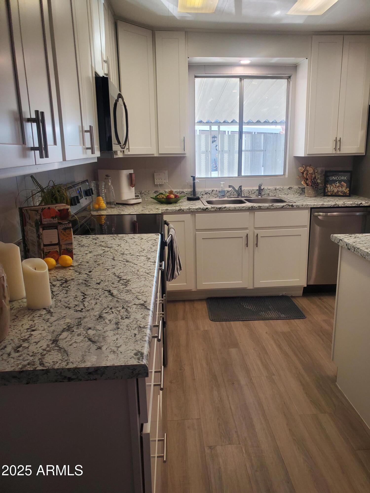 3300 East Broadway Road, Unit 128 Mesa, AZ 85204 - Photo 8 of 32 a kitchen with granite countertop a sink cabinets and wooden floor
