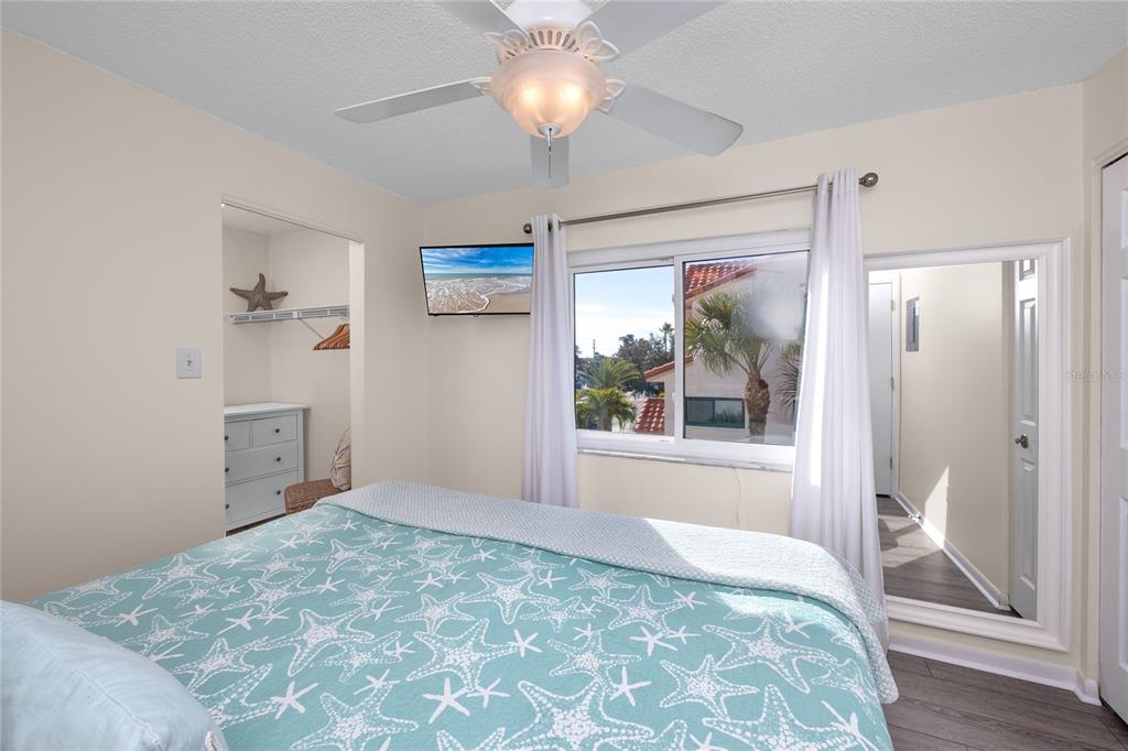 1300 Gulf Boulevard, Unit 301 Indian Rocks Beach, FL 33785 - Photo 20 of 46 a bedroom with a bed and a chandelier